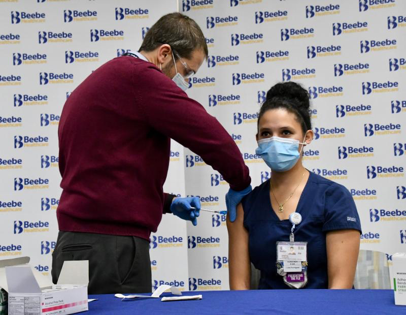 On Dec. 16, 2020, Beebe Healthcare’s Dr. William Chasanov administers nurse Sintia Rodriguez a COVID-19 vaccine shot, the first shot in Sussex County.